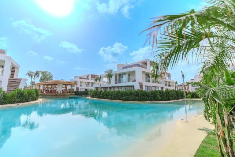 White residences around a lagoon-style pool, an example of property for sale in Belek